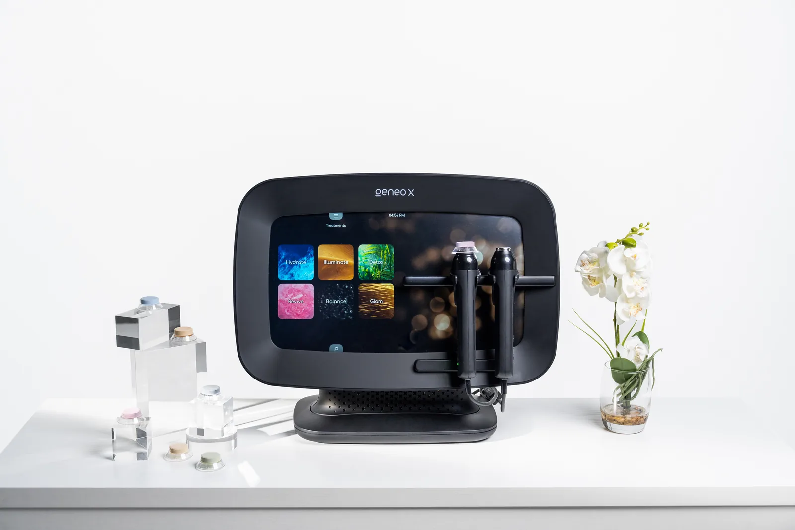 The Geneo X device with its OxyPod treatment menu on screen and two docked handpieces