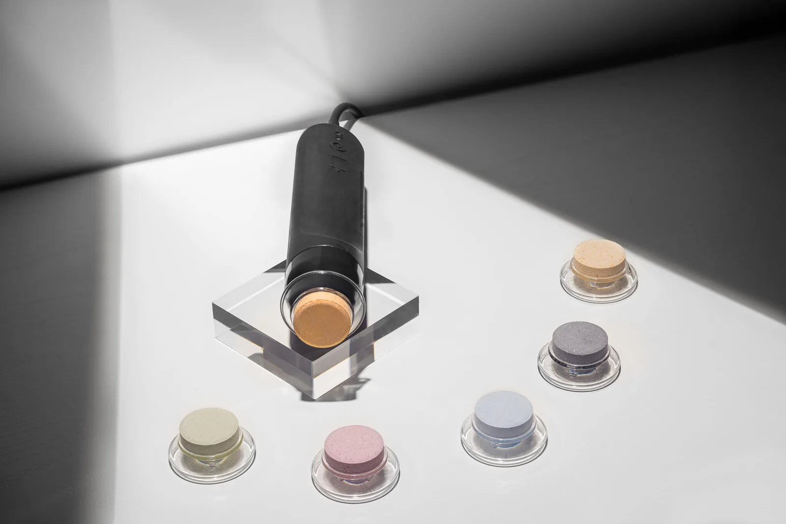 Geneo X handpiece docked beside a set of colorful Glo2Facial OxyPod treatment pods